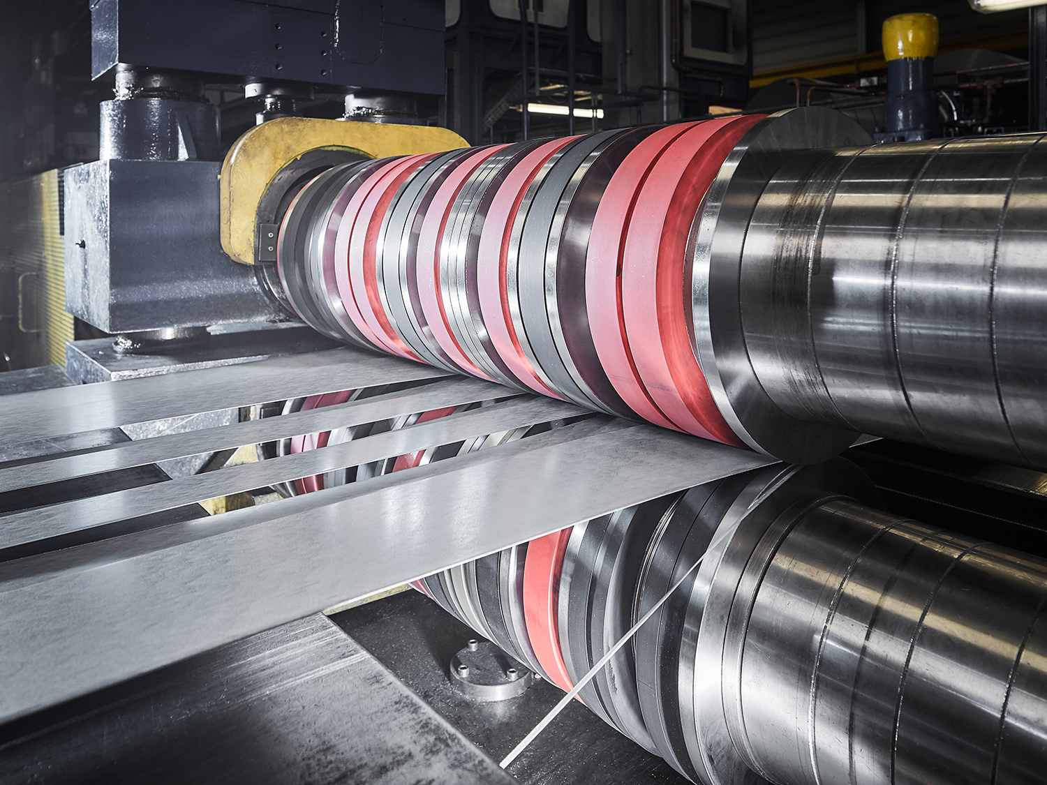 OKS_Landscape_06 Stacks of coiled steel rolls in various sizes and finishes organized in a steel service center, showcasing the variety of steel products available for industrial use.